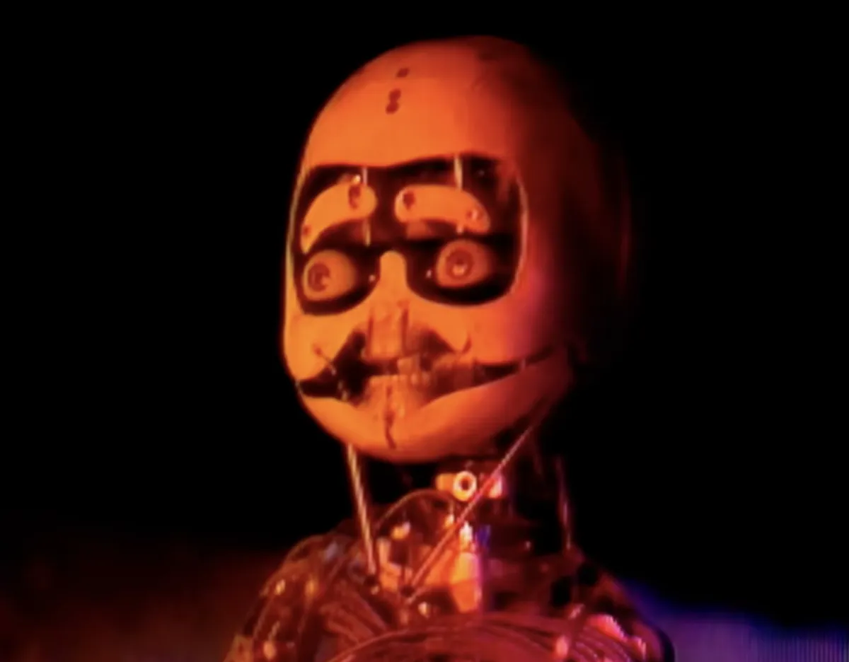 a red-lit robot with a human skull-like face.